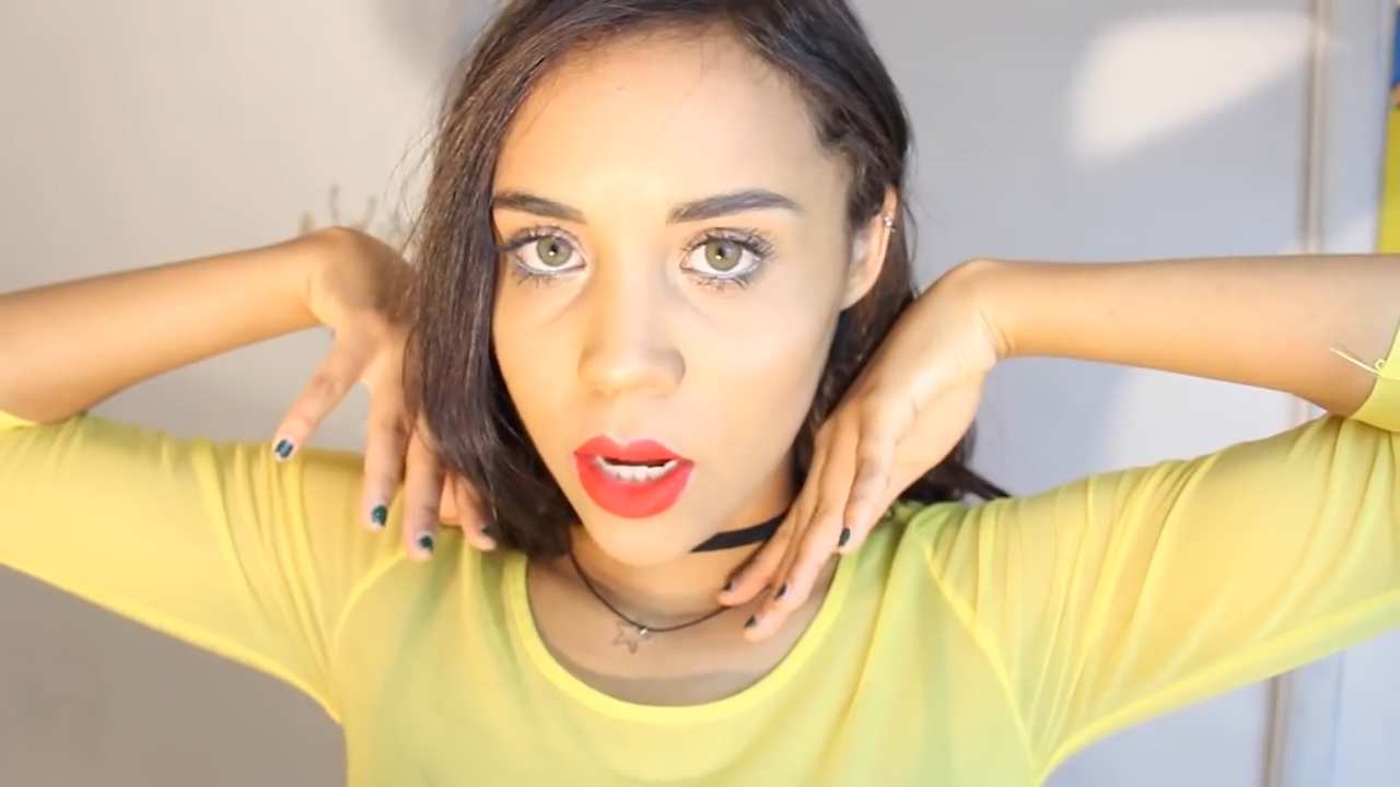 a girl with her arms bent and hands at her cheeks